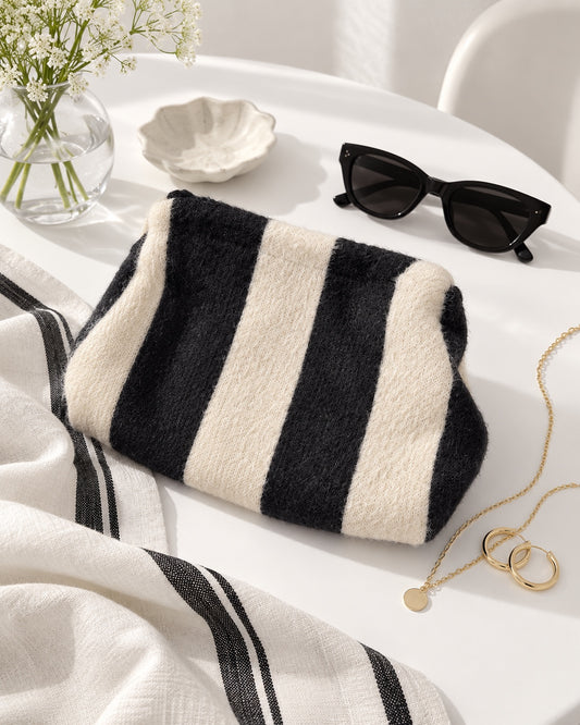 Bolso pouch de rayas negro y crudo con cadena dorada extraíble