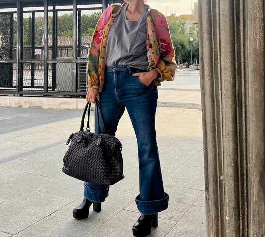 Chaqueta mostaza bordada con flores rosas y verdes, combinada con vaqueros
