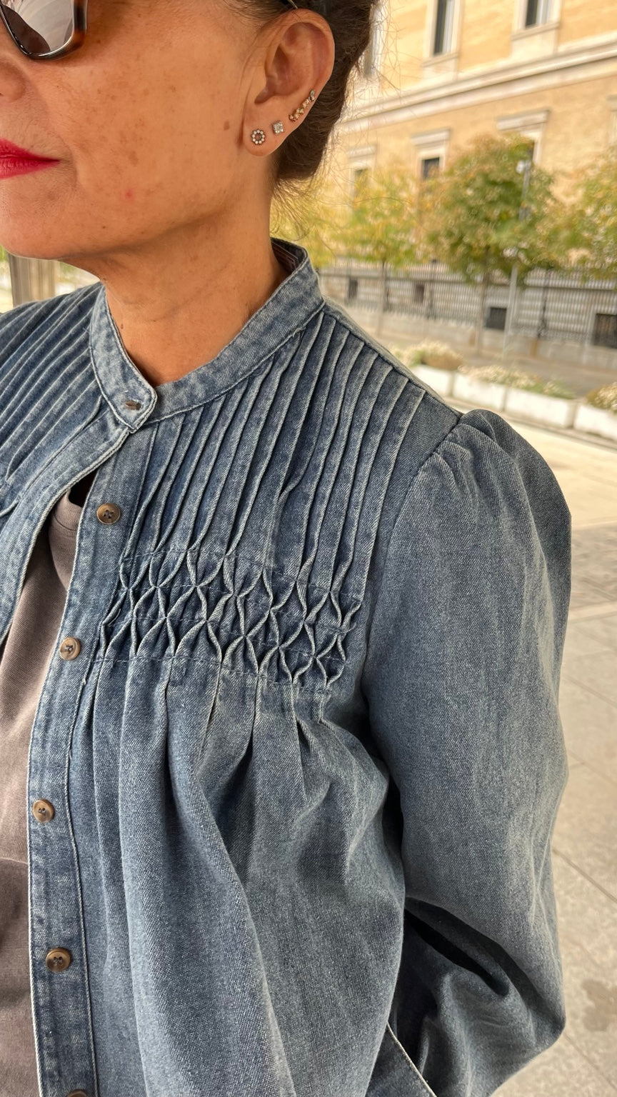 Detalle del cuello, botones y nido de abeja de la camisa vaquera azul