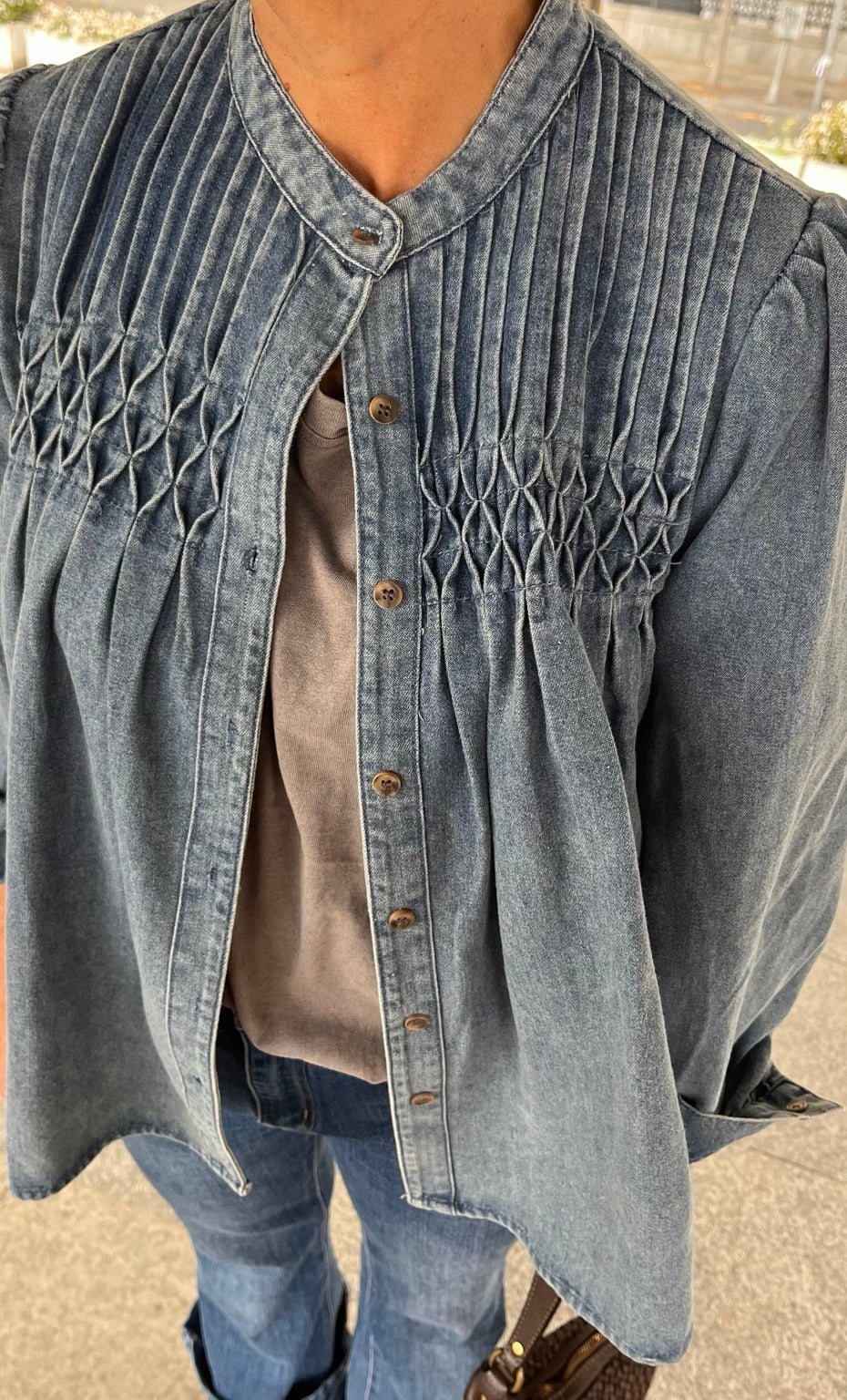 Detalle frontal de la camisa vaquera azul y su nido de abeja