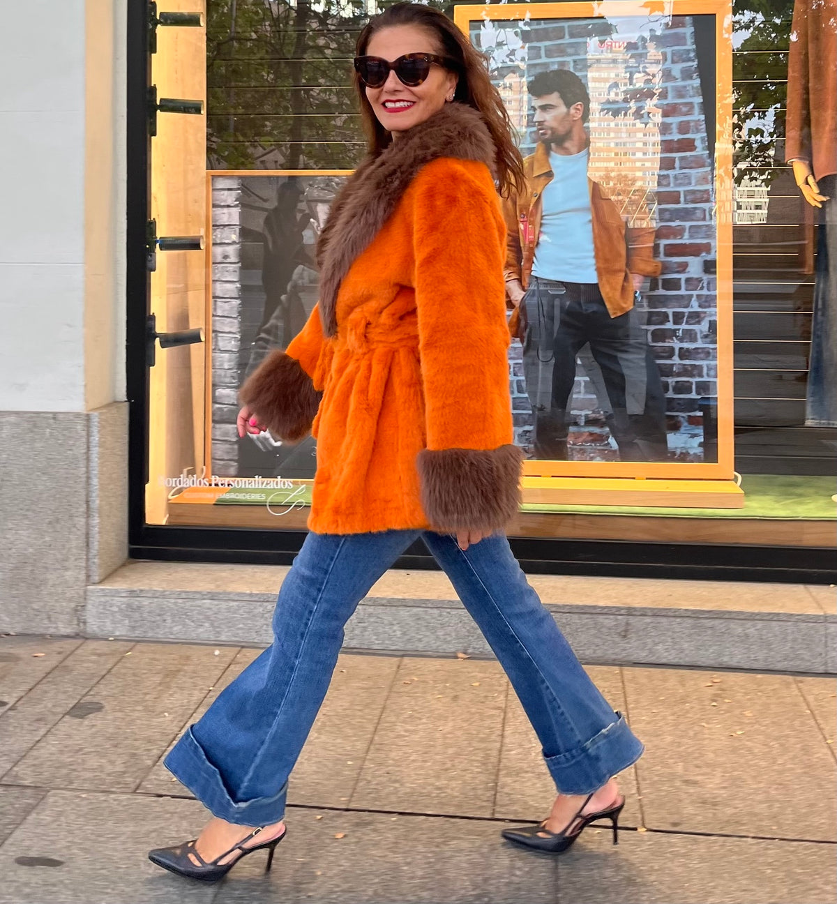 Look de calle con abrigo naranja de peluche y vaqueros