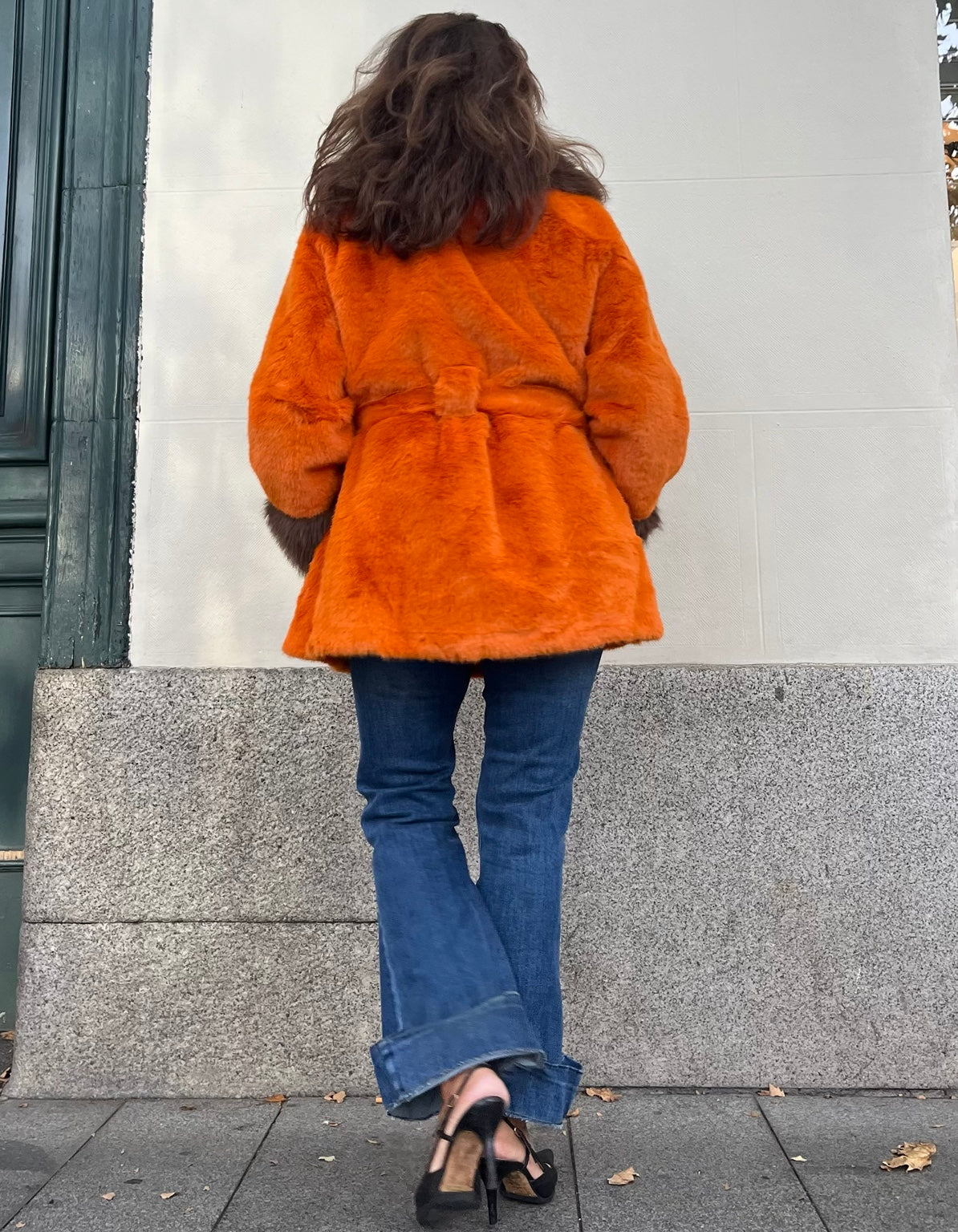 Vista de espalda del abrigo naranja de peluche con cinturón