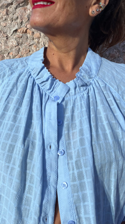 Detalle cuello fruncido y botones de camisa azul cielo