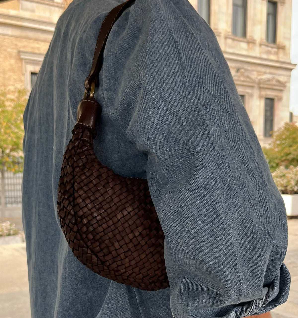 Bolso bandolera marrón trenzado llevado al hombro