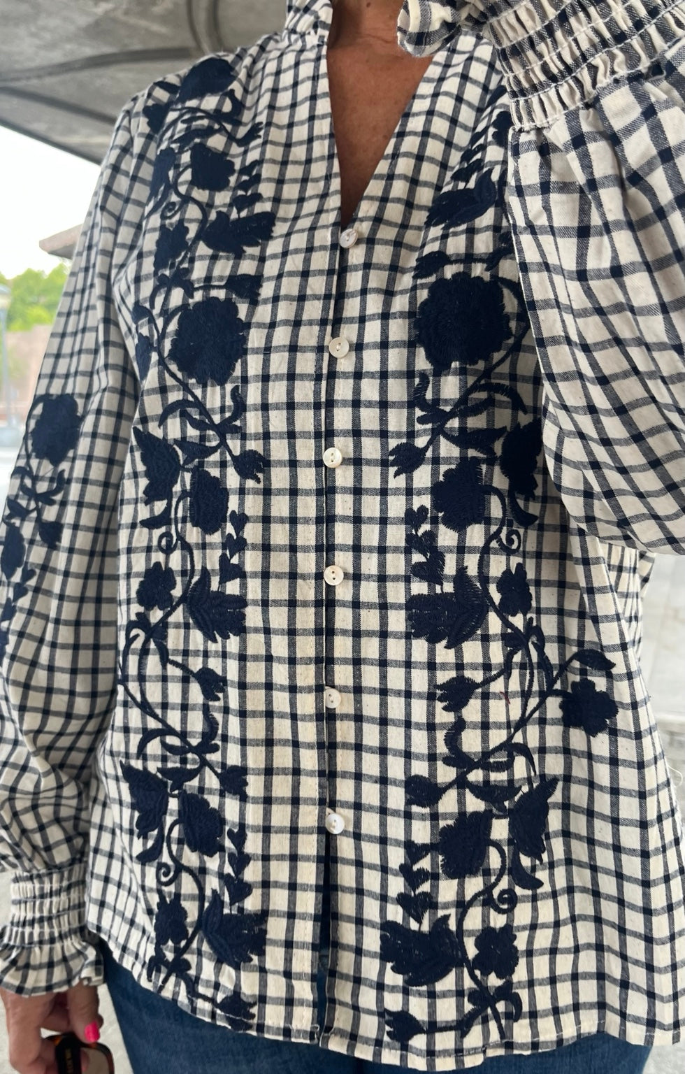 Detalle frontal de camisa de algodón cuadros con bordado azul marino