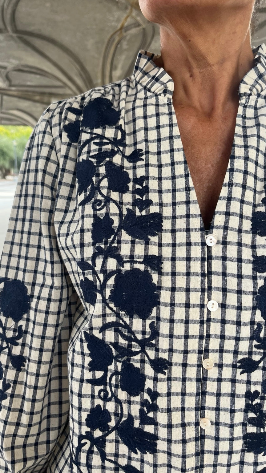 Detalle cuello con volante y bordado azul marino