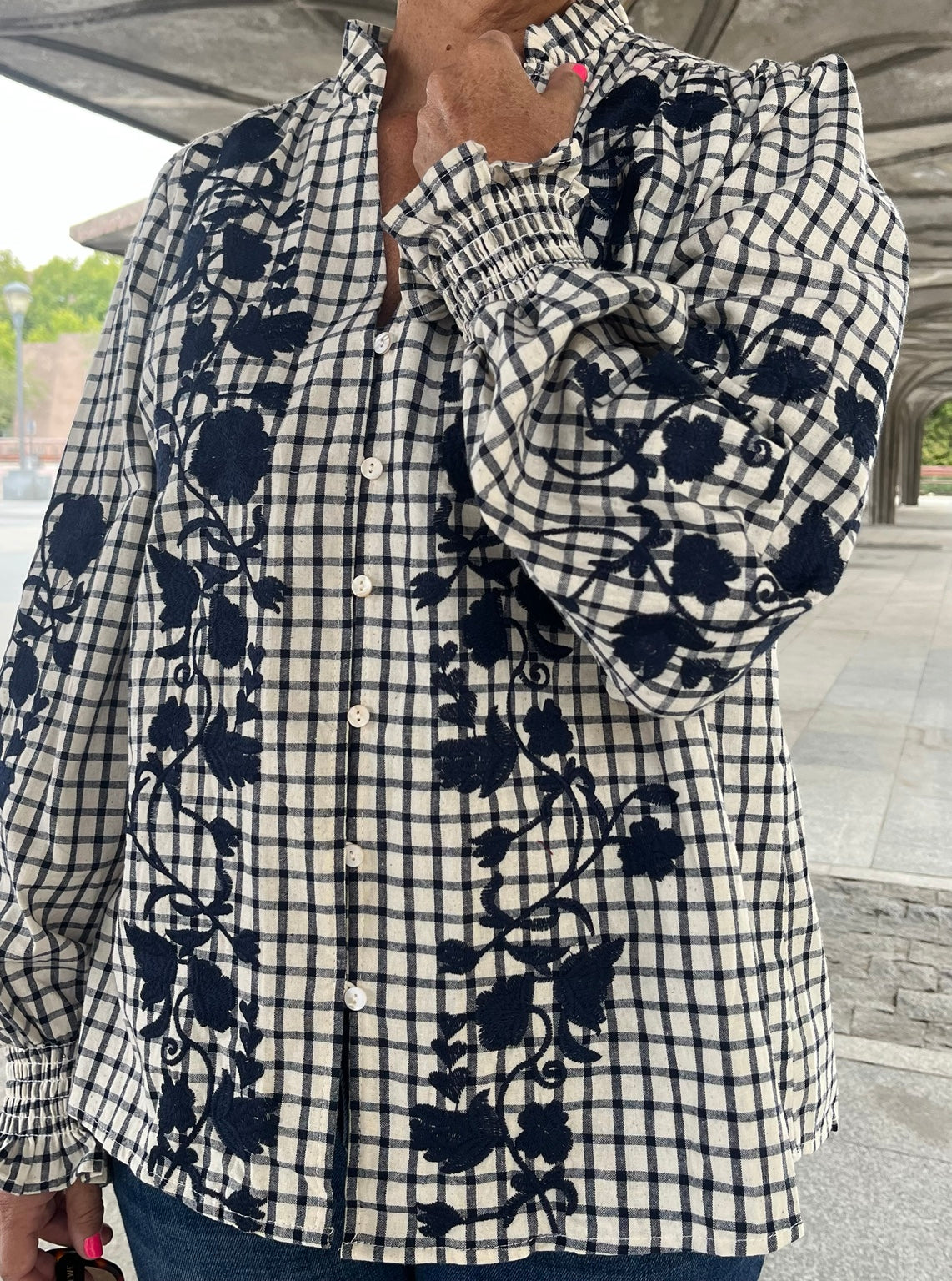 Detalle manga y puño fruncido de camisa con bordado azul marino