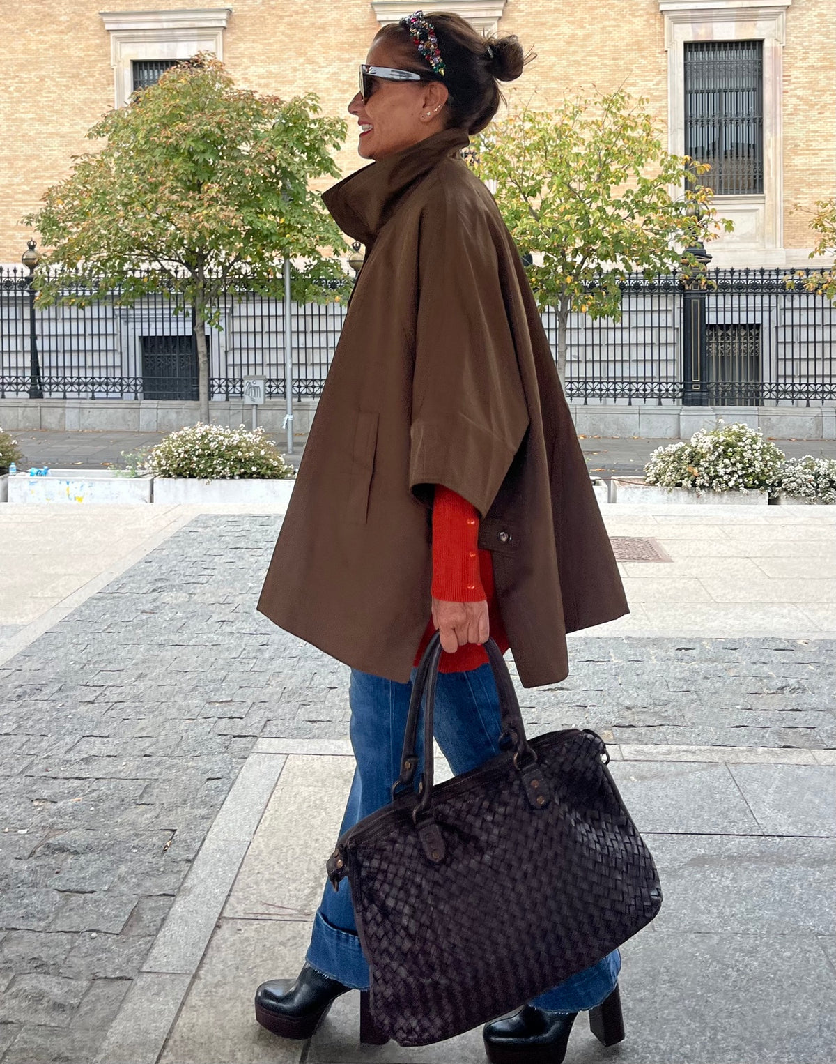 Chaqueta capa oversize marrón vista lateral con bolso trenzado