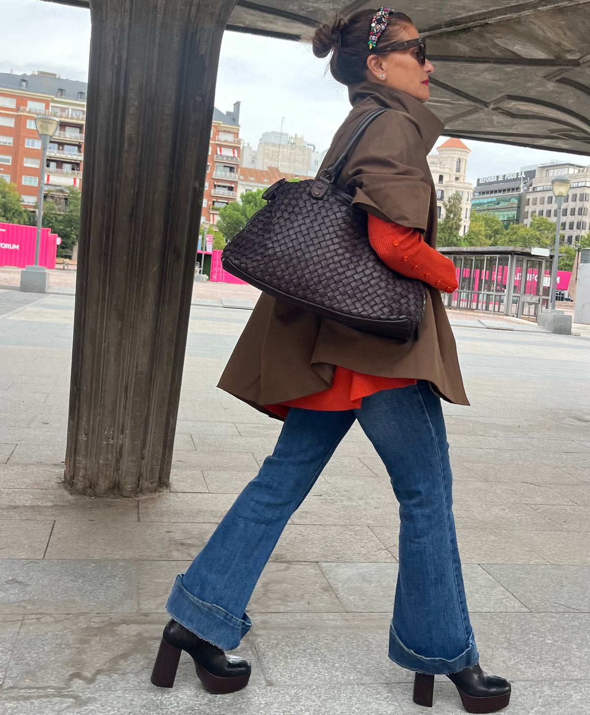 Chaqueta capa oversize marrón en movimiento con bolso al hombro