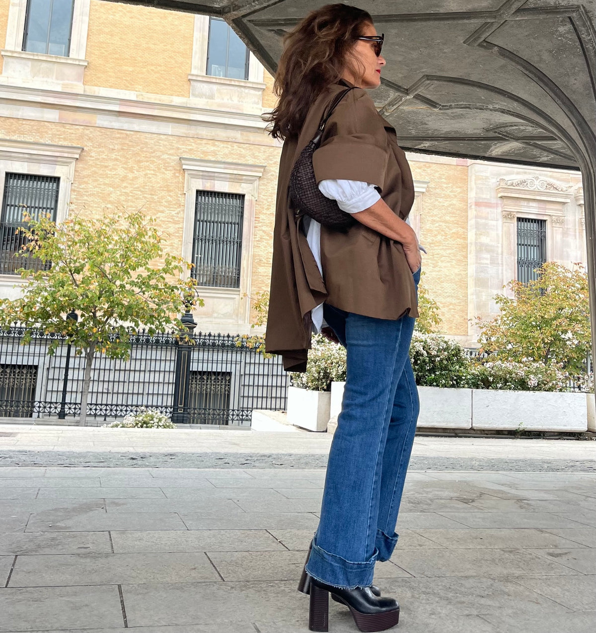 Chaqueta capa oversize marrón combinada con camisa blanca
