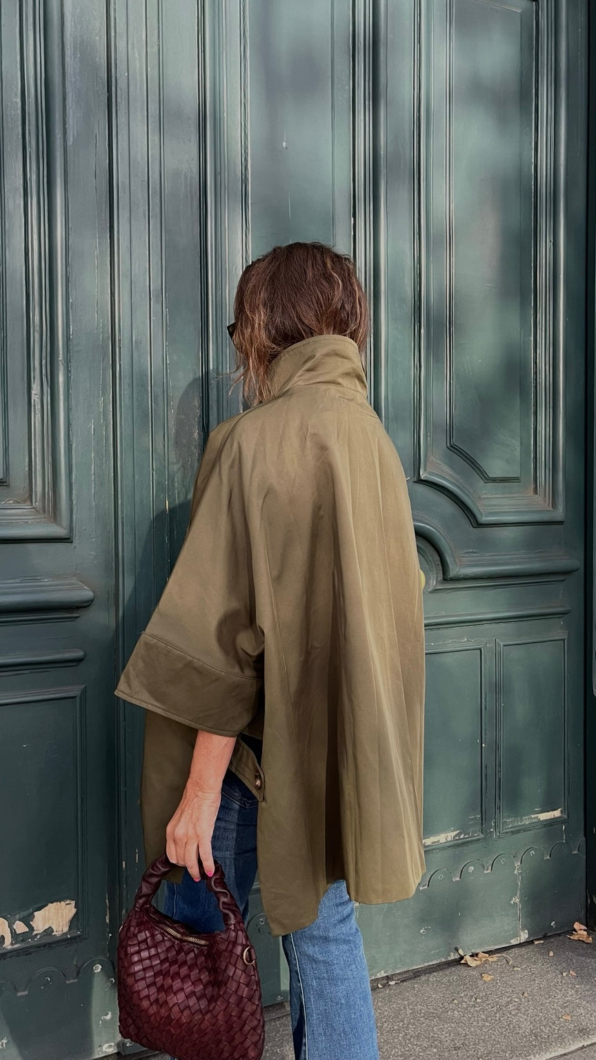 Chaqueta capa oversize verde caqui vista posterior junto a puerta verde