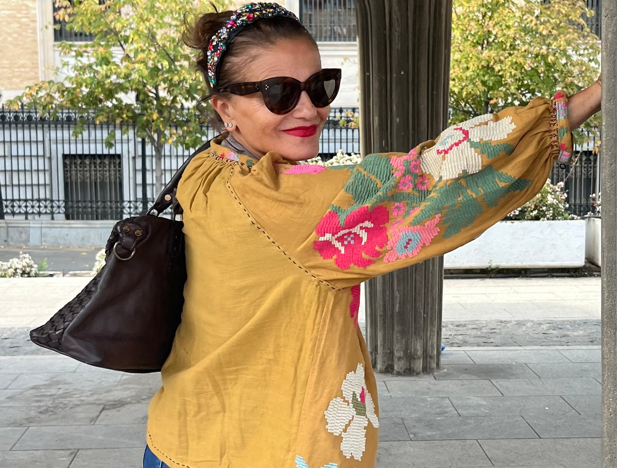 Vista de espalda de la chaqueta mostaza con bordado floral en las mangas