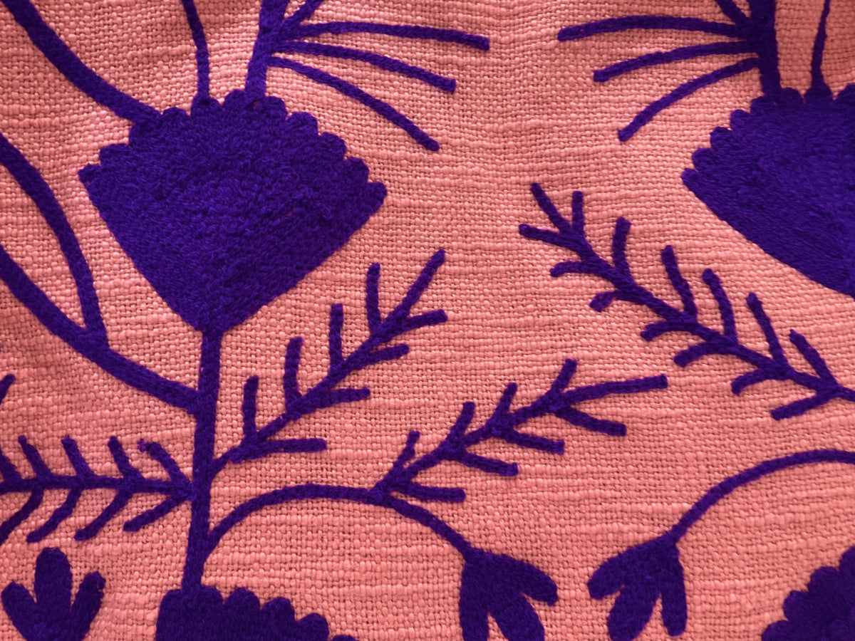 Detalle del tejido y bordado morado de la chaqueta salmón tostado